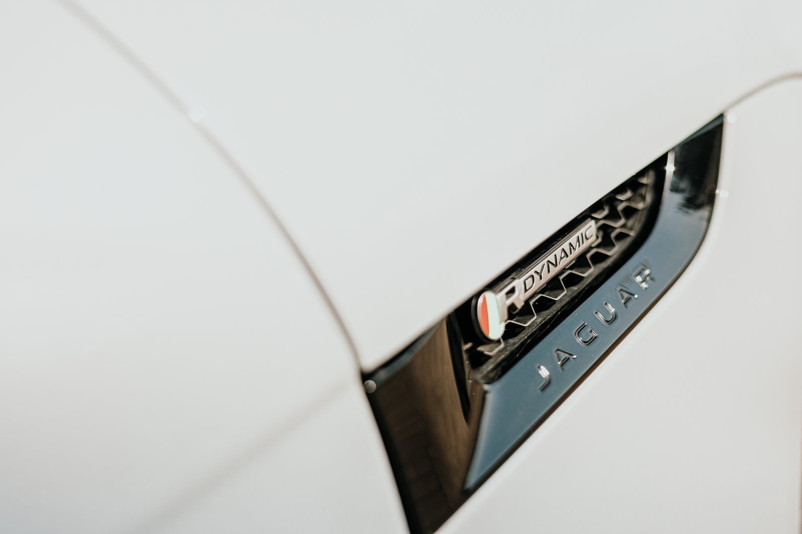 Dettaglio badge R-Dynamic sul parafango di una Jaguar F-Type, richiamo di storia e originalità Dettaglio badge R-Dynamic sul parafango di una Jaguar F-Type, richiamo di storia e originalità
