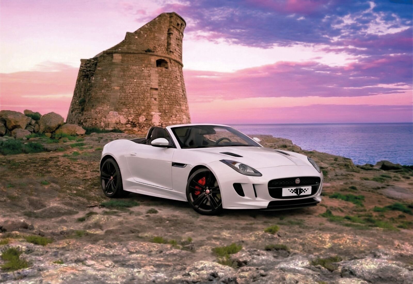 Jaguar F-Type R-Dynamic Convertible bianco perlato davanti alla torre di Porto Miggiano, Salento, al tramonto Jaguar F-Type R-Dynamic Convertible bianco perlato davanti alla torre di Porto Miggiano, Salento, al tramonto
