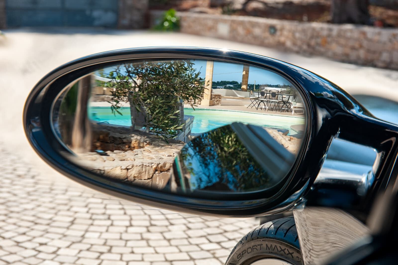 Specchietto retrovisore della Porsche 911 con il riflesso della piscina e di un ulivo Specchietto retrovisore della Porsche 911 con il riflesso della piscina e di un ulivo