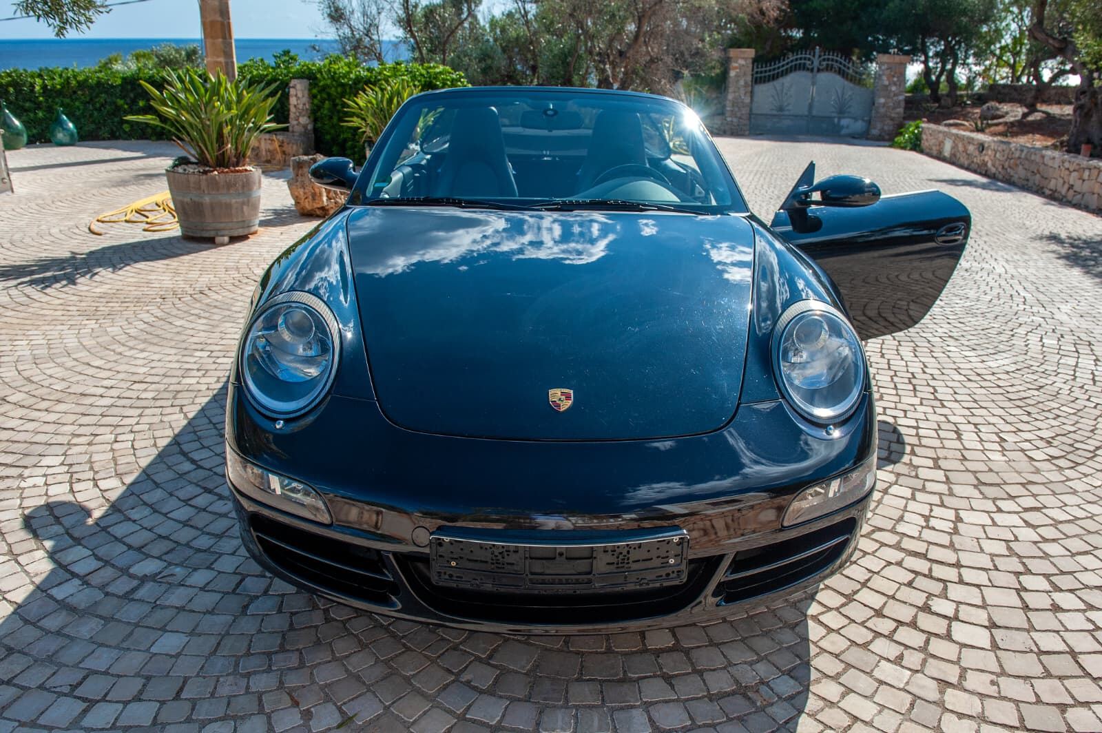 Porsche 911 Carrera 4 Cabriolet, vista frontale con il mare del Salento sullo sfondo Porsche 911 Carrera 4 Cabriolet, vista frontale con il mare del Salento sullo sfondo